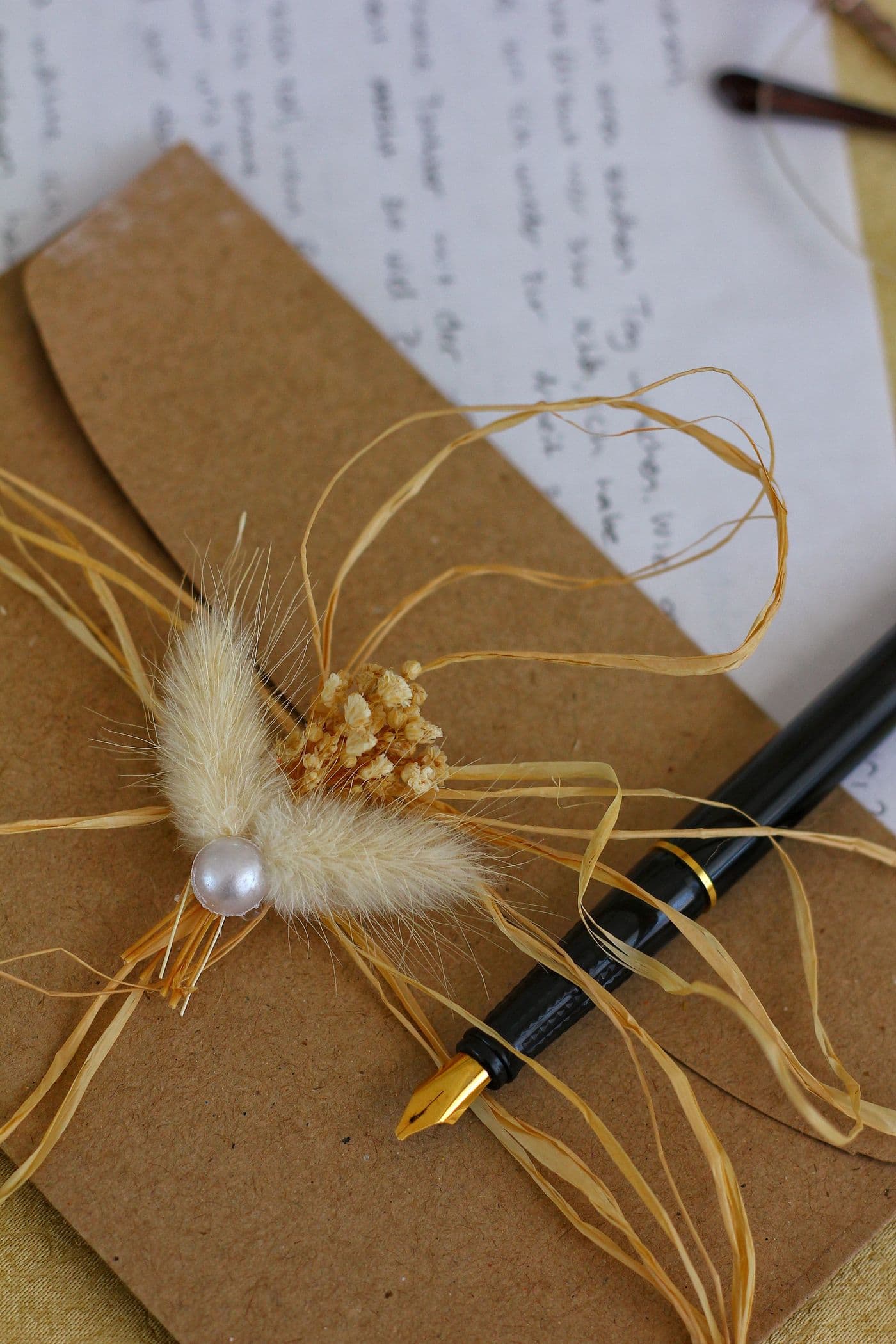 Una busta di carta con fiori secchi e una penna stilografica