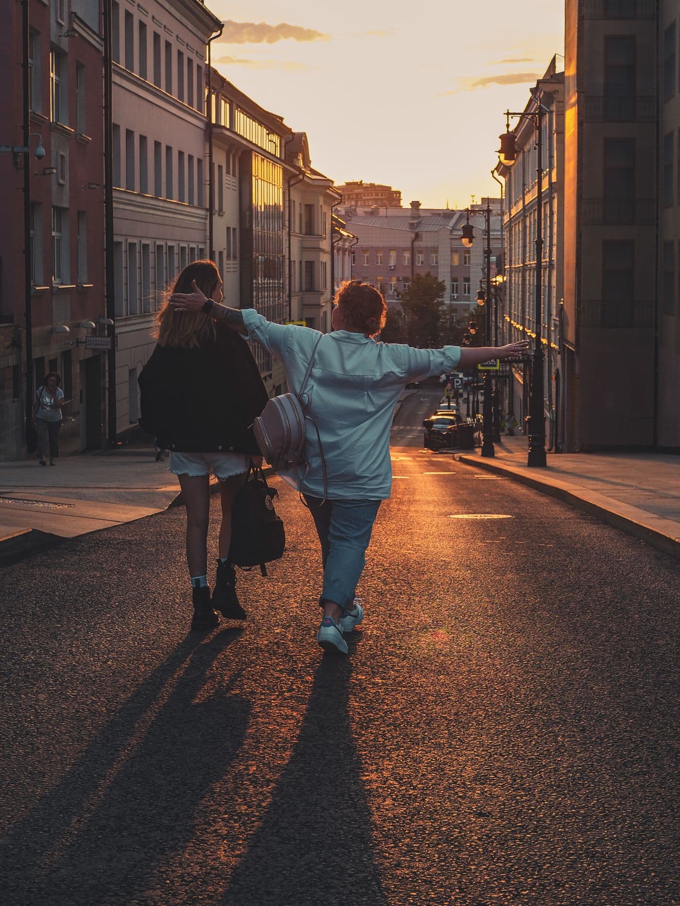 Due amiche camminano insieme in una strada al tramonto