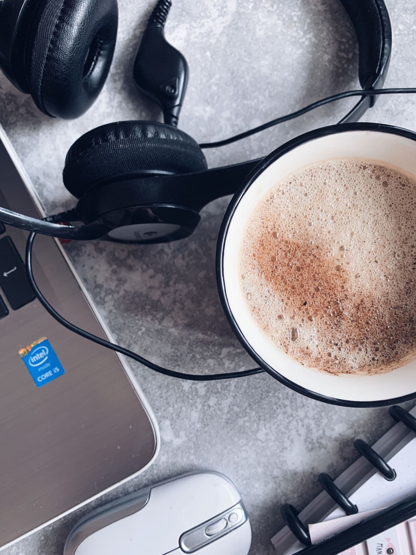 Cuffie, una tazza di cappuccino e un computer portatile